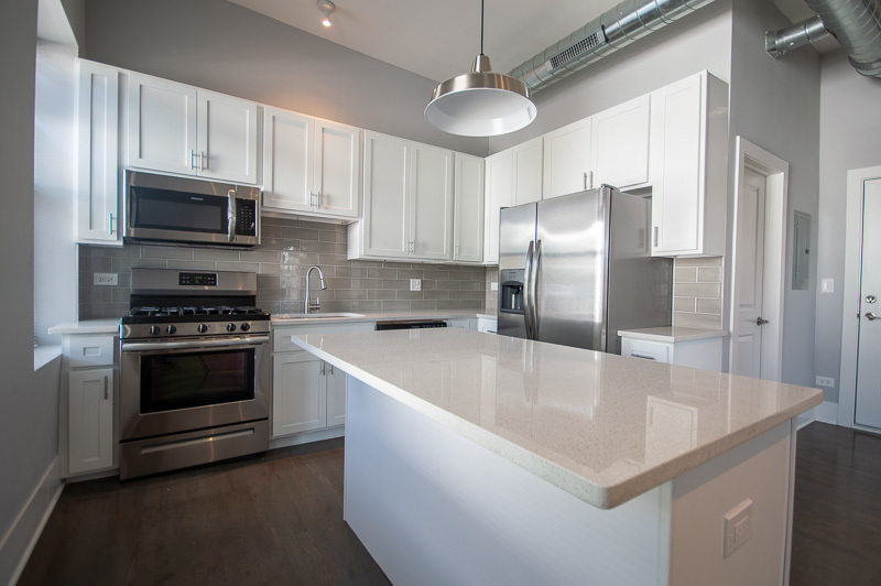 1044 West 18th Street, Unit 3F Chicago, IL 60608 - Photo 2 of 8 a kitchen with stainless steel appliances granite countertop a sink a stove and a refrigerator