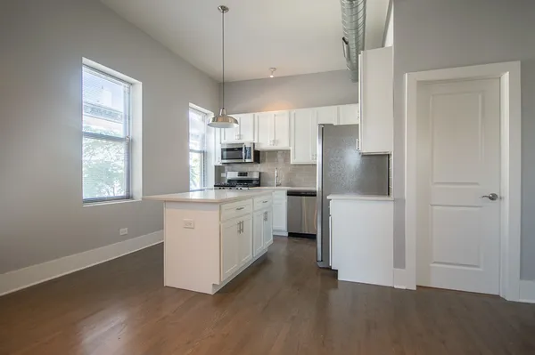 a kitchen with white cabinets and white appliances