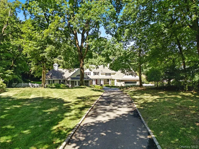 a view of a house with a big yard and large trees