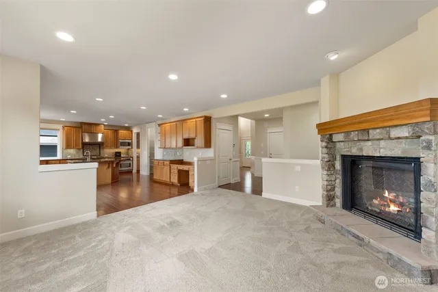 a view of an empty room and kitchen with fireplace walk in closet