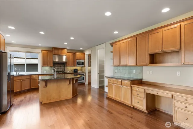 a kitchen with stainless steel appliances granite countertop wooden cabinets a sink and a stove