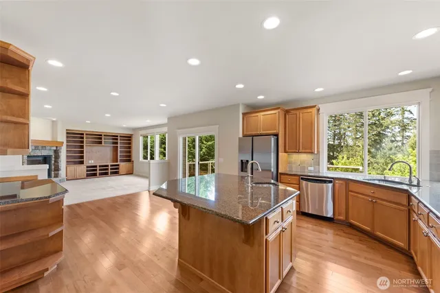 a kitchen with stainless steel appliances granite countertop sink stove and refrigerator