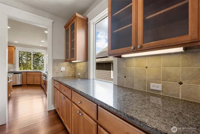 a view of a kitchen with a sink and wooden cabinets
