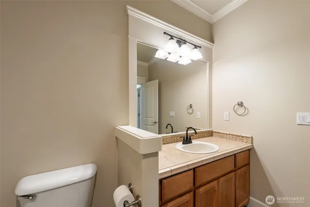 a bathroom with a sink vanity mirror and toilet