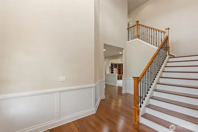 a view of staircase with wooden floor and white walls