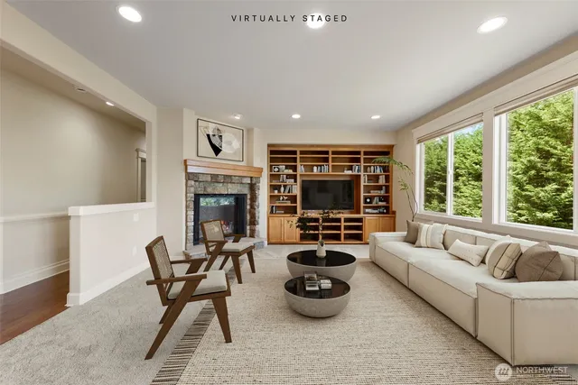 a living room with furniture a fireplace and a large window