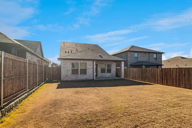 a view of a house with a wooden fence