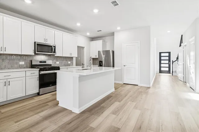 a kitchen with stainless steel appliances a refrigerator sink and cabinets