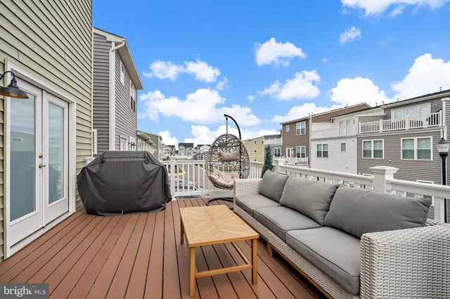 a view of a roof deck with couches and wooden floor