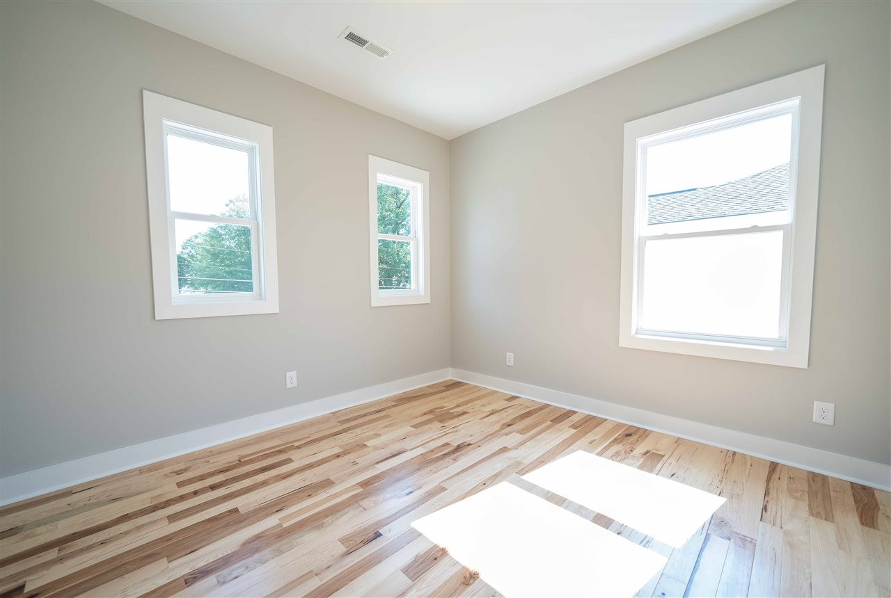 2318 Milburnie Road Raleigh, NC 27610 - Photo 19 of 28 a view of an empty room with wooden floor and a window