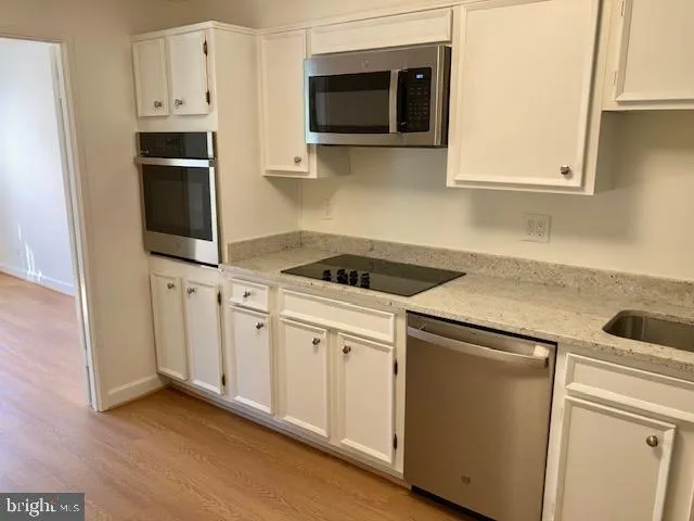 a view of walk in closet with wooden floor