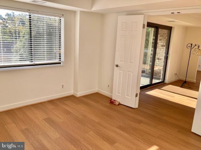 5902 Mt Eagle Drive, Unit 106 Alexandria, VA 22303 - Photo 46 of 73 an empty room with wooden floor and windows