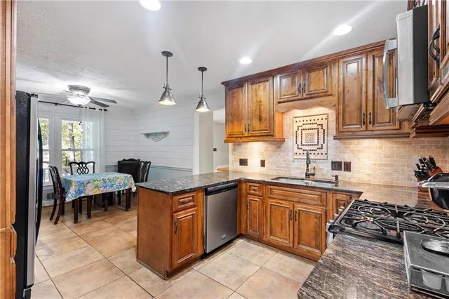 a kitchen with stainless steel appliances a sink stove and cabinets