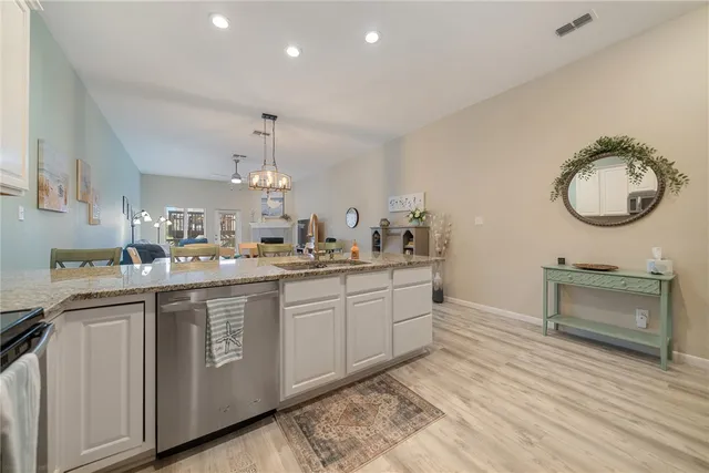a kitchen with a sink cabinets and wooden floor