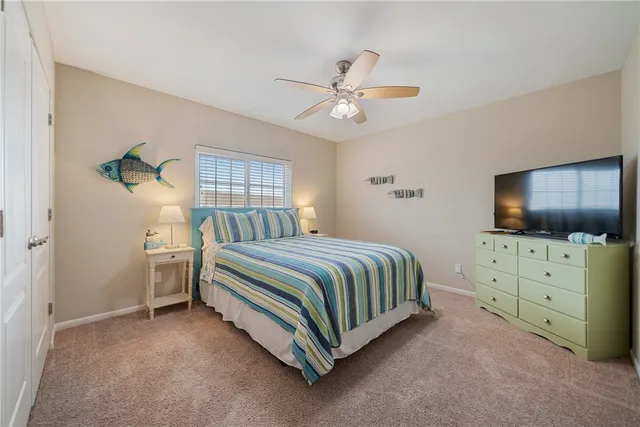 a bedroom with a large bed and a flat tv screen on dresser