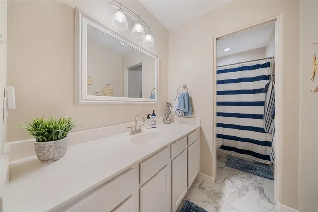 a bathroom with a sink a potted plant and a mirror