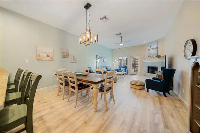 a view of a dining room with furniture a rug and wooden floor