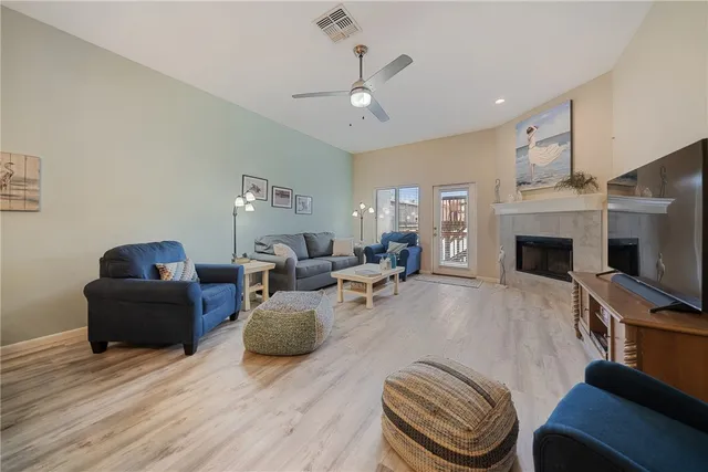 a living room with furniture a fireplace and a flat screen tv