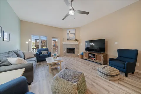 a living room with furniture a flat screen tv and a fireplace