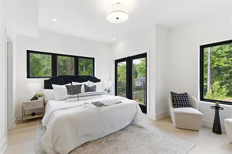a bedroom with a bed and a large window