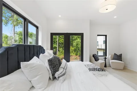 a bedroom with a bed and large windows