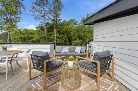 a view of a patio with table and chairs and potted plants with wooden floor and fence
