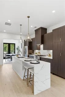 a kitchen with a stove a refrigerator and a view of living room