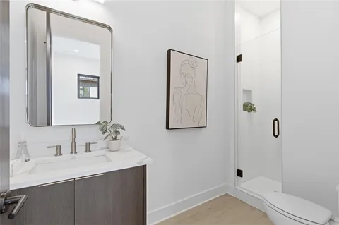 a bathroom with a sink a toilet and shower