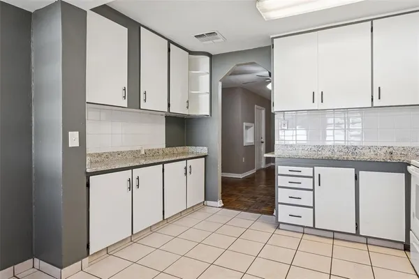 a kitchen with granite countertop a sink cabinets and stainless steel appliances