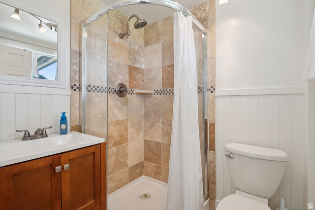 550 Pine Canyon Road Midway, UT 84049 - Photo 30 of 44 Tile shower enclosure with a curved glass door, accented by a decorative mosaic band