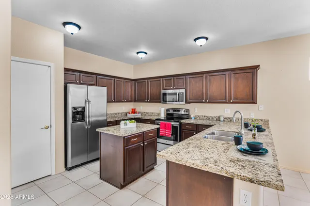 a kitchen with stainless steel appliances granite countertop a sink stove and refrigerator