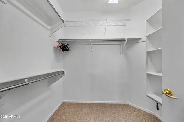 a view of walk in closet with empty racks