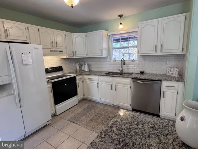 a kitchen with a white cabinets and white appliances