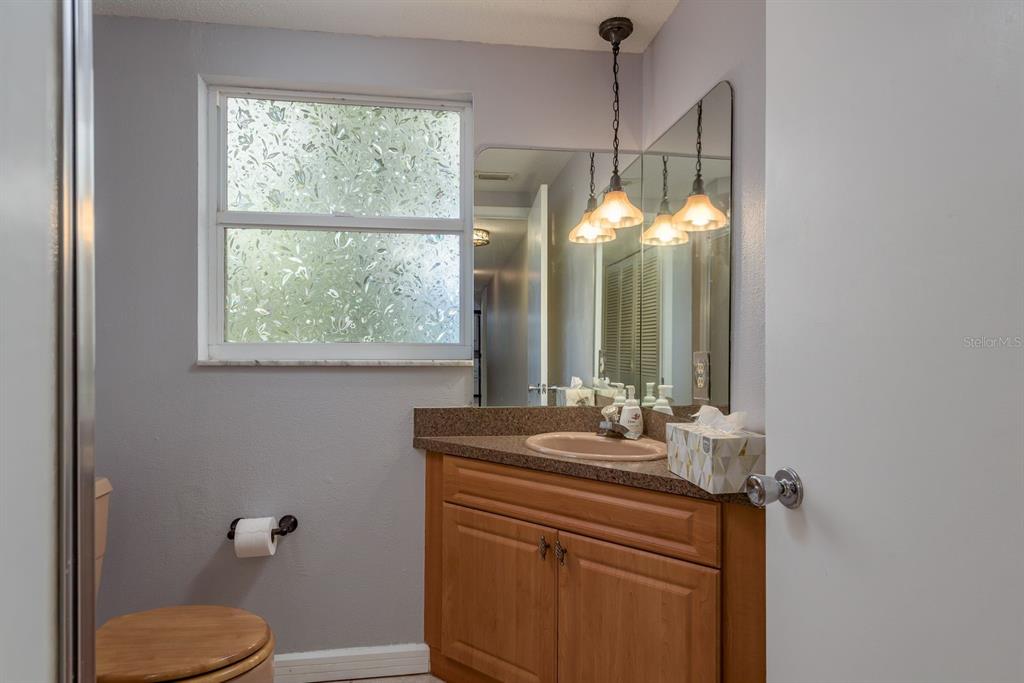 2279 Ranchette Lane Dunedin, FL 34698 - Photo 27 of 50 a bathroom with a sink vanity mirror and toilet
