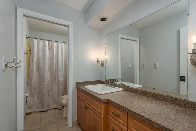 a view of a patio with a table and chairs under an umbrella with a barbeque