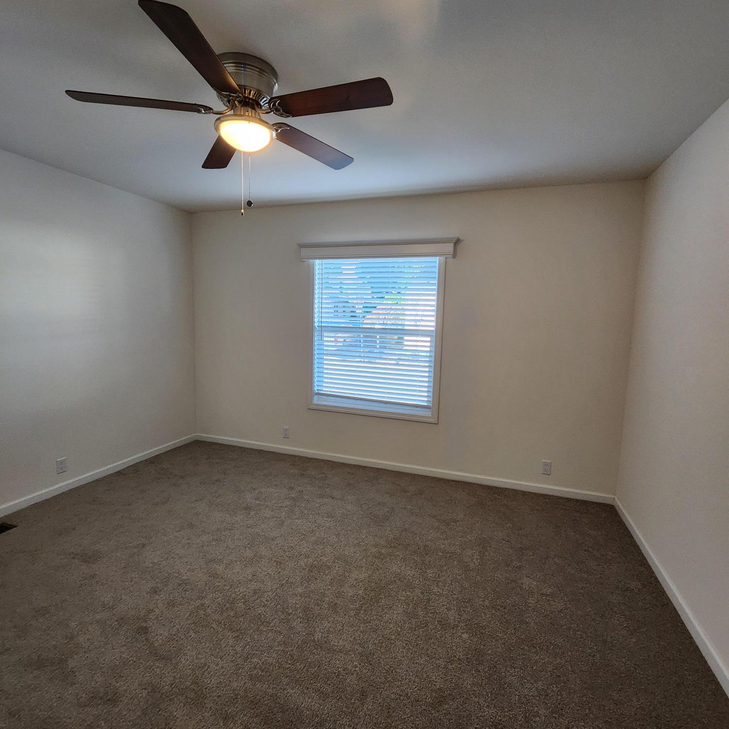 350 Pleasant Valley Road, Unit 49 Diamond Springs, CA 95619 - Photo 11 of 13 an empty room with a ceiling fan and windows