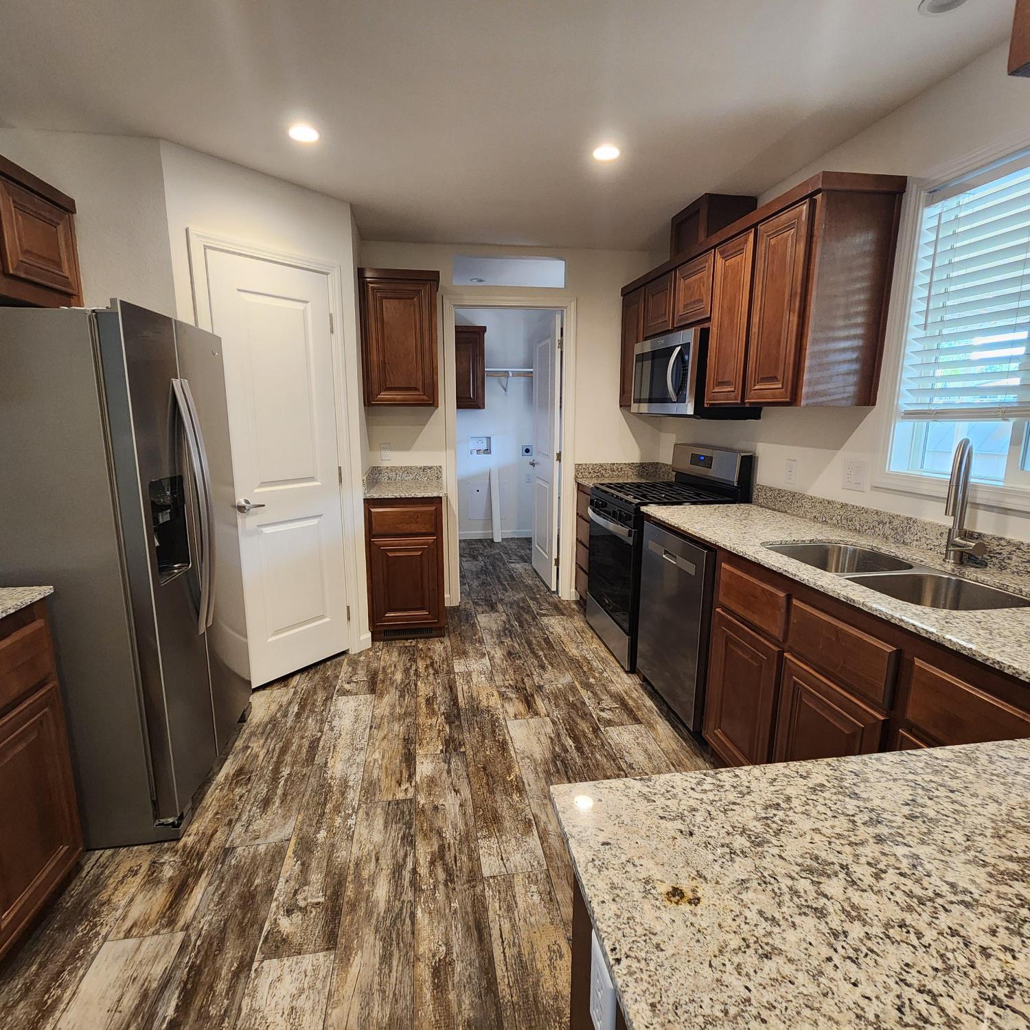 350 Pleasant Valley Road, Unit 49 Diamond Springs, CA 95619 - Photo 4 of 13 a kitchen with stainless steel appliances granite countertop a refrigerator stove microwave and sink