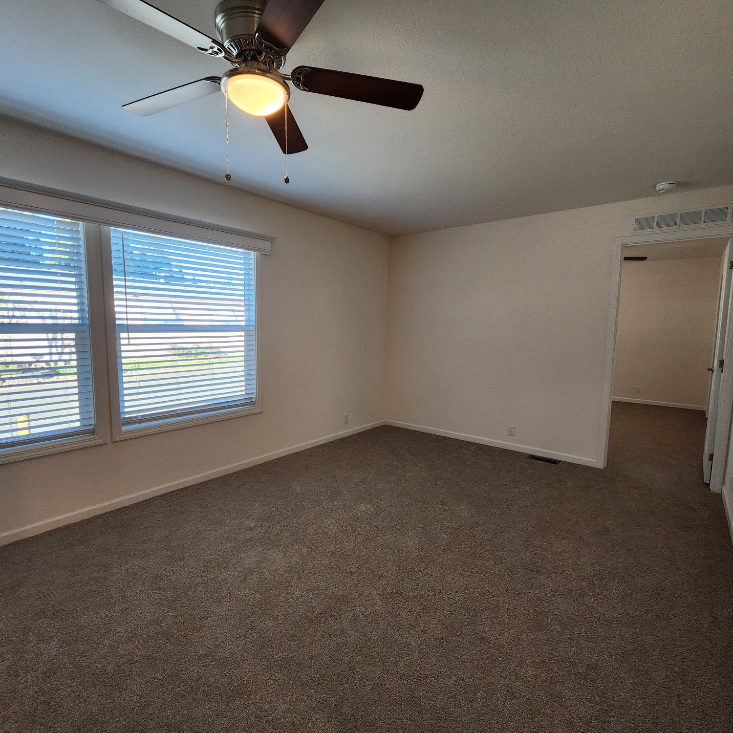 350 Pleasant Valley Road, Unit 49 Diamond Springs, CA 95619 - Photo 6 of 13 an empty room with windows and fan