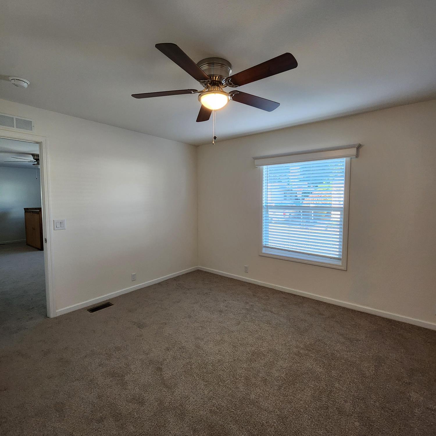 350 Pleasant Valley Road, Unit 49 Diamond Springs, CA 95619 - Photo 9 of 13 an empty room with a ceiling fan and window