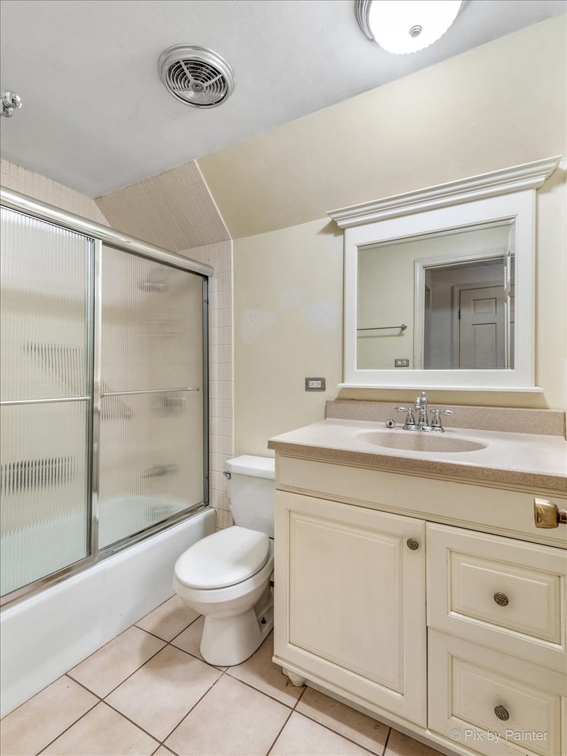 8 Woodbine Road Rolling Meadows, IL 60008 - Photo 22 of 44 a bathroom with a toilet a sink a mirror and a glass door shower