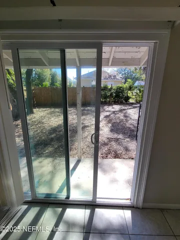a view of a glass door with a yard from a window