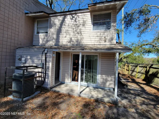 a view of a house with a door and wooden fence