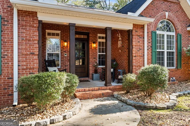 a front view of a house with a tree