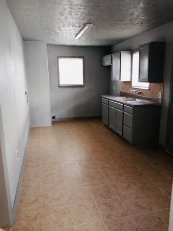 a kitchen with granite countertop a sink cabinets and a window