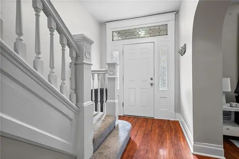 a view of a hallway with wooden floor and staircase