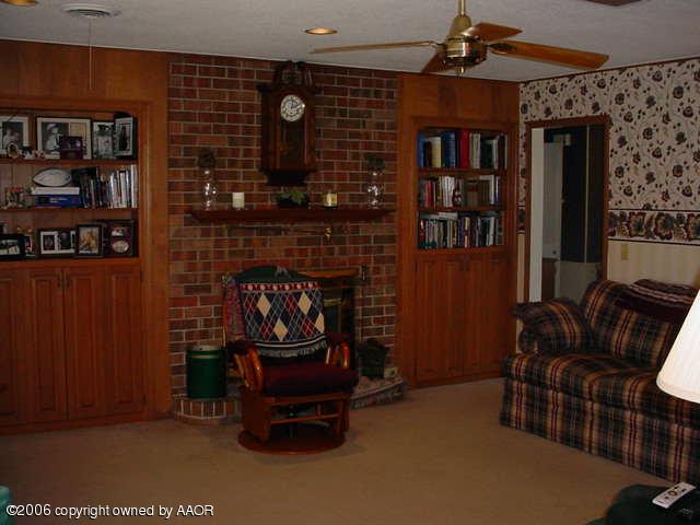 6303 Gainsborough Road Amarillo, TX 79106 - Photo 3 of 12 a living room with furniture a rug and a fireplace