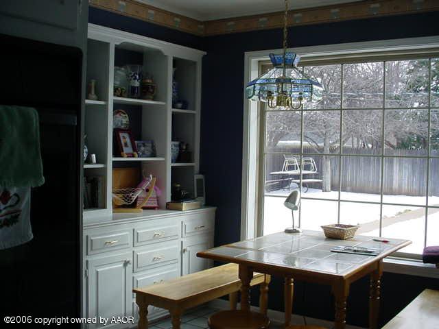 6303 Gainsborough Road Amarillo, TX 79106 - Photo 8 of 12 a kitchen with a table chairs and cabinets