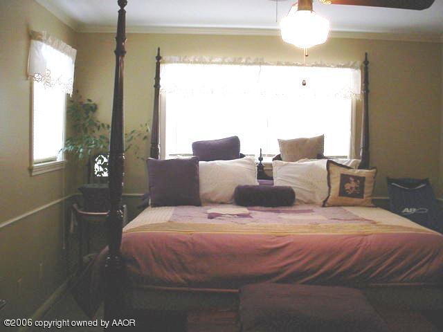 6303 Gainsborough Road Amarillo, TX 79106 - Photo 9 of 12 a bedroom with a bed and wooden floor