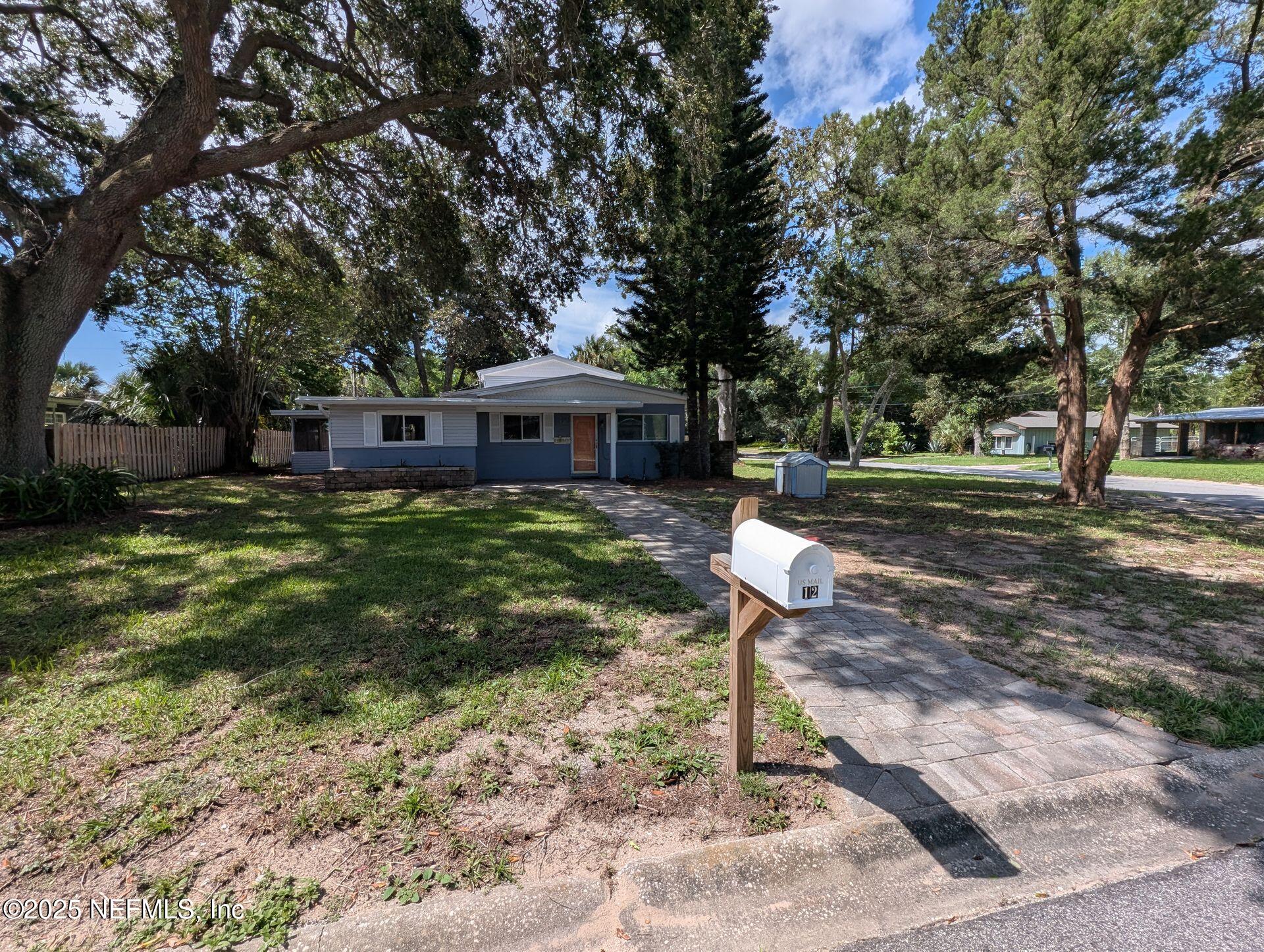 a view of a house with backyard and a tree