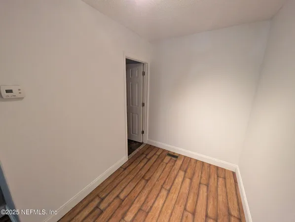 a view of an empty room with wooden floor